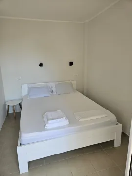 Bedroom with a large double bed and white linens. - image 11