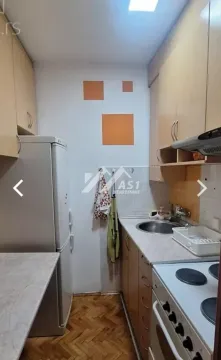 Manja kuhinja sa drvenim elementima, frižiderom i šporetom. - image 7