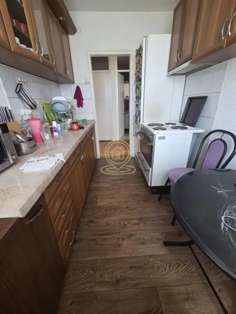 Small kitchen with wooden cabinetry, stove, and a dining table.