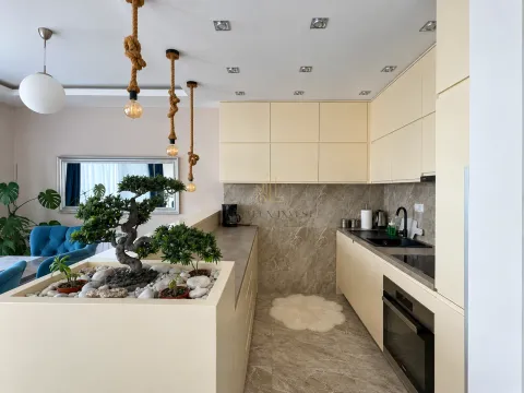 Kitchen with beige cabinets and a decorative partition wall with plants. - image 4