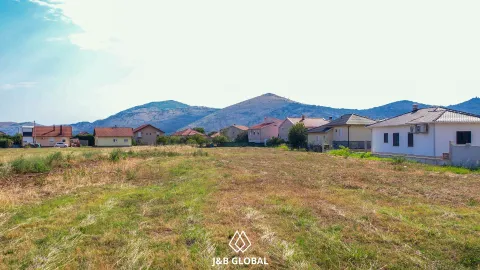 Pogled na plac sa travnatom površinom i kućama u okruženju. - image 5