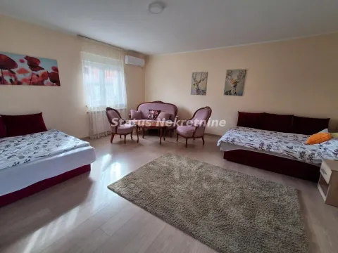 Dnevna soba sa garniturom za sedenje i krevetima. - image 23