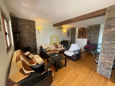 Living room with sofa set, wooden flooring, and stone wall accents. - image 2