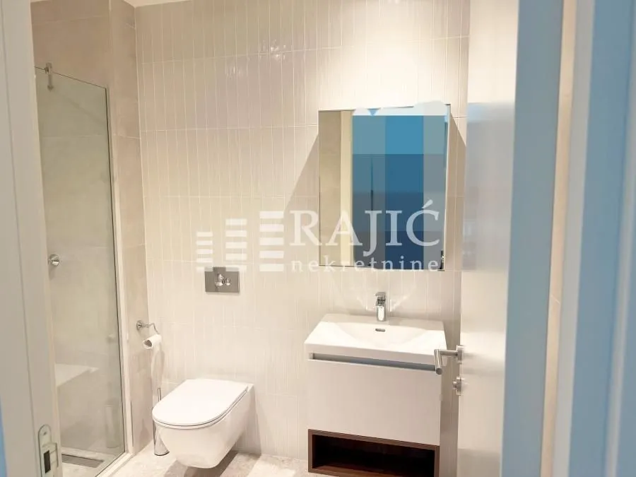 Modern bathroom with a sink, toilet, and walk-in shower.