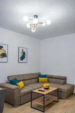 Living room with a sectional sofa, coffee table, and modern ceiling lighting. - image 12