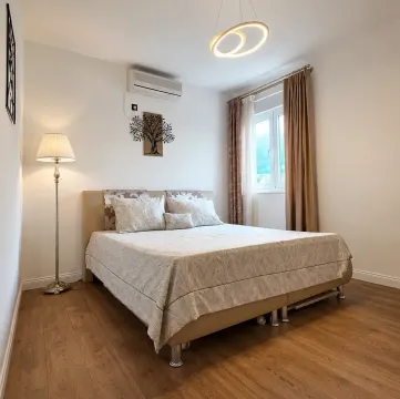 Namještena spavaća soba sa bračnim krevetom, podnom lampom i klima uređajem. - image 11