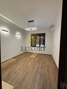 Empty room with wooden flooring and modern lighting fixtures. - image 2
