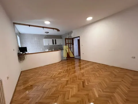 Prostrana dnevna soba sa parketom i pogledom na kuhinjski šank. - image 8