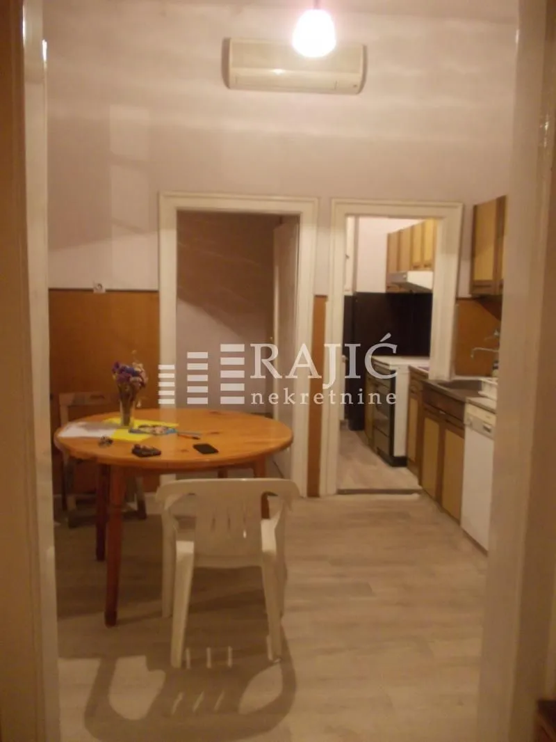 Dining area with a table and chairs, looking into the kitchen.