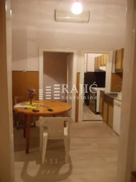 Dining area with a table and chairs, looking into the kitchen. - image 11
