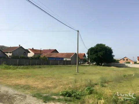 Pogled na plac sa travnatom površinom i kućama u pozadini. - image 2