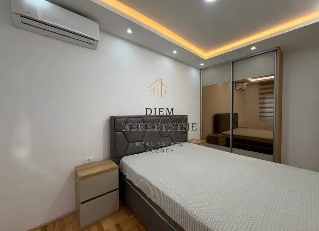 Furnished bedroom with a double bed, wardrobe, and air conditioning.