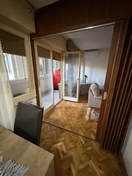 Pogled iz prostorije prema dnevnoj sobi i terasi sa drvenim parketom. - image 21