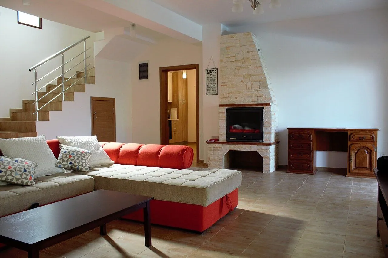 Spacious living room with a sectional sofa, fireplace, and staircase.