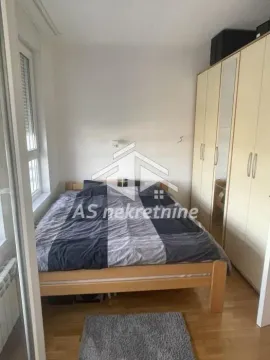 Nameštena spavaća soba sa bračnim krevetom i velikim ormanom. - image 10