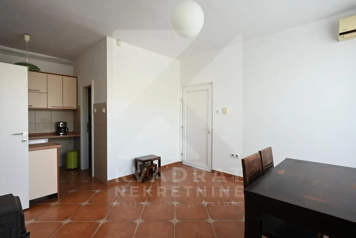 Living room with a dining area and a small kitchen corner.
