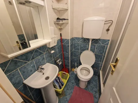 Small bathroom with a sink, toilet, and wall-mounted mirror cabinet. - image 15