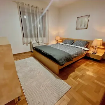 Furnished bedroom with a double bed and parquet flooring. - image 6