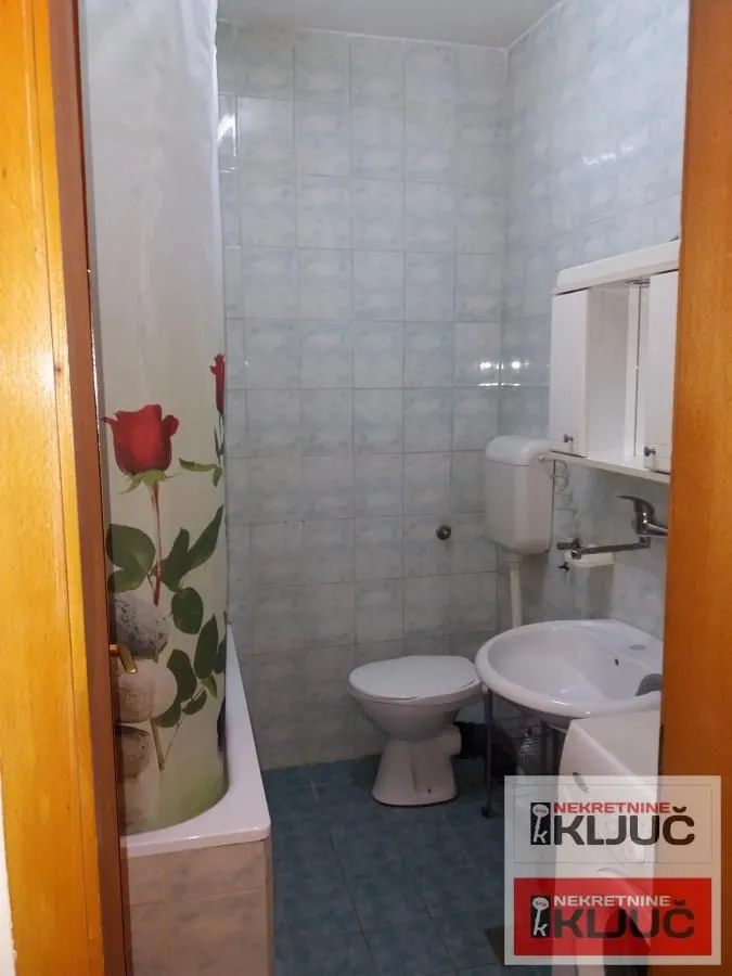 Smaller bathroom with a bathtub, washbasin, and toilet.