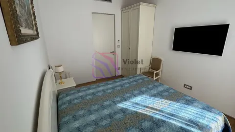Spavaća soba sa bračnim krevetom, garderoberom, radnim stolom i televizorom na zidu. - image 9