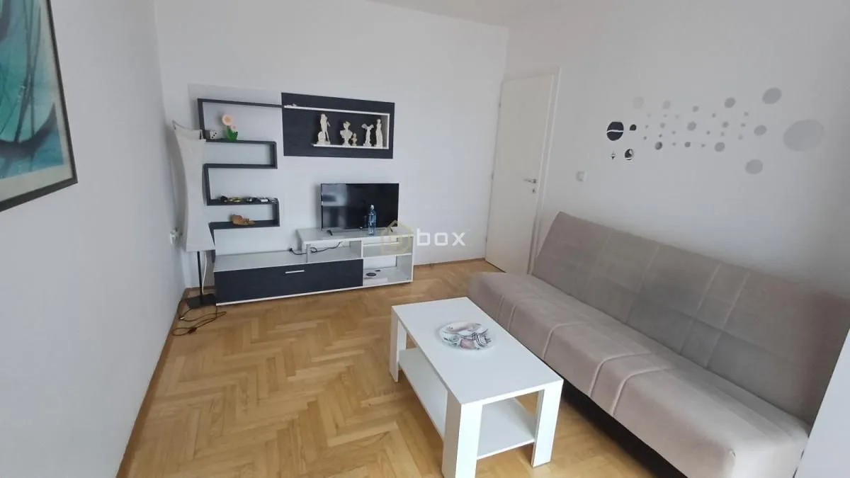 Living room with sofa, coffee table and TV.