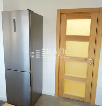 Part of the kitchen with a refrigerator and wooden door. - image 3