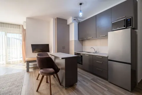 Modern kitchen with dark cabinets, a dining island, and access to the terrace. - image 3