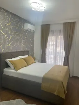 Furnished bedroom with a double bed, patterned wallpaper, and air conditioning. - image 7
