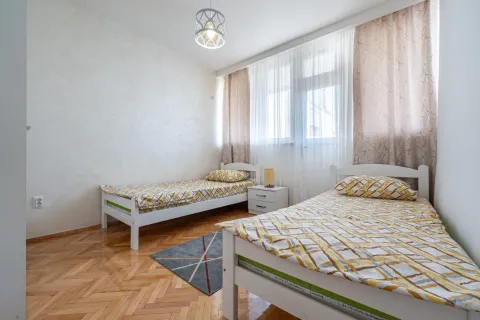 A bedroom with two single beds and parquet flooring. - image 7