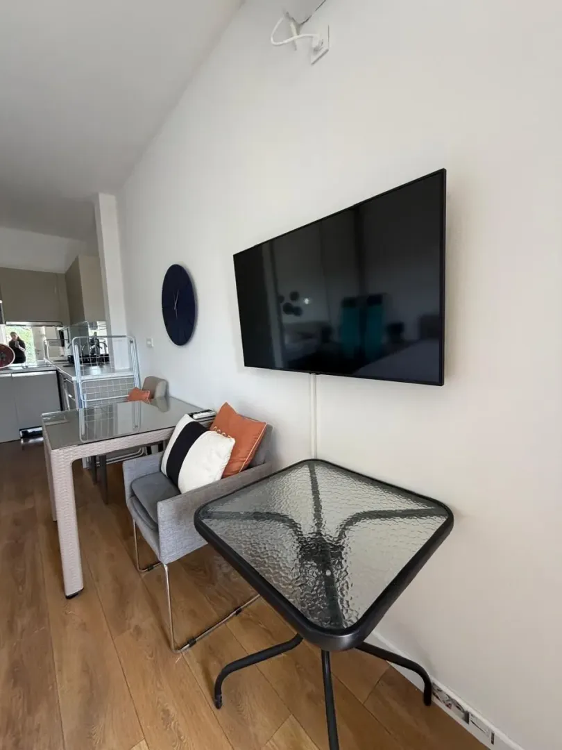 Living room with a dining table and a wall-mounted TV.