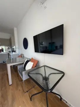 Living room with a dining table and a wall-mounted TV. - image 6