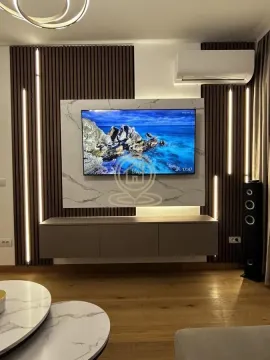 Living room with TV, modern wood paneling, and decorative lighting. - image 10