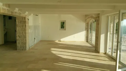 A spacious empty room featuring stone arches and large glass doors. - image 7