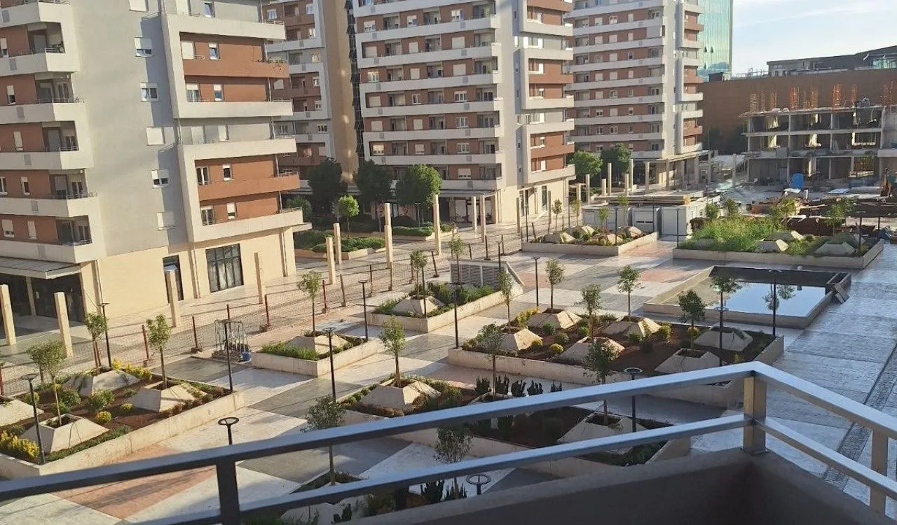 Pogled sa terase na uređeno dvorište i okolne stambene zgrade.
