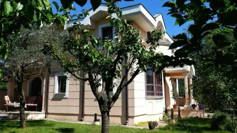 Two-story family house with a landscaped yard and greenery. - image 3