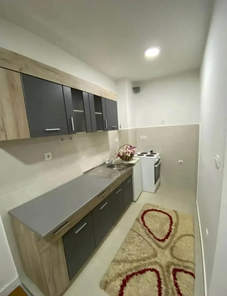 Small kitchen with dark cabinets and a white stove.
