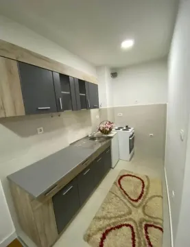 Small kitchen with dark cabinets and a white stove. - image 5