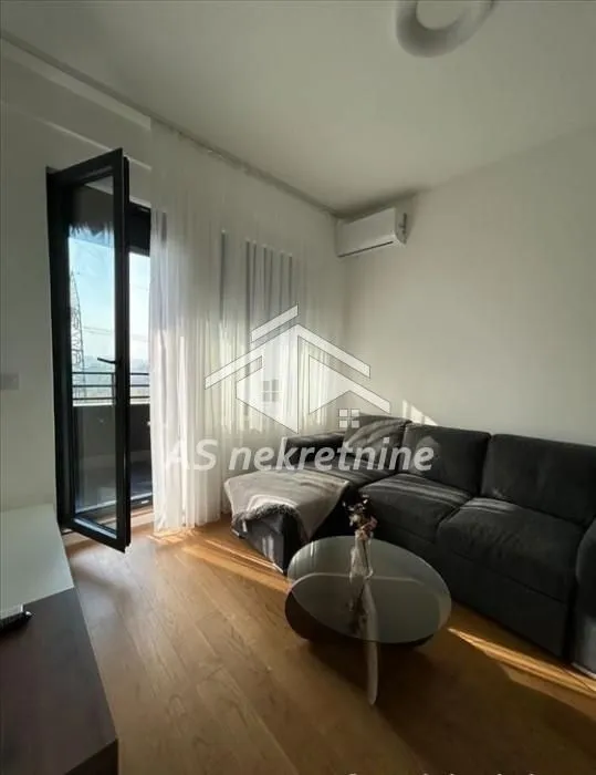 Living room with a sectional sofa, coffee table, and access to the terrace.