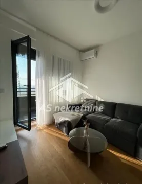 Living room with a sectional sofa, coffee table, and access to the terrace. - image 2