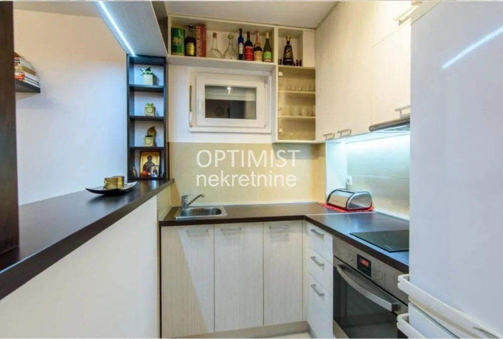 Smaller kitchen with cabinetry and built-in appliances.