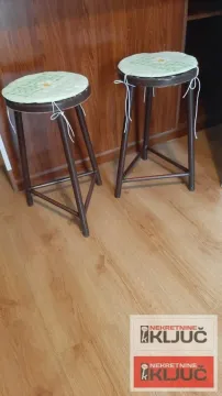 Detalj sa dve drvene stolice i jastucima na podu od laminata. - image 11