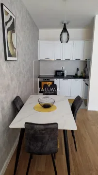 Kitchen with dining table and white cabinets. - image 4