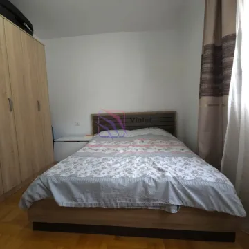 Spavaća soba sa bračnim krevetom i drvenim ormarom. - image 8