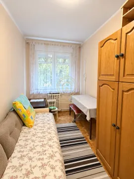 Manja spavaća soba sa krevetom, drvenim garderoberom i stolom sa stolicom pored prozora. - image 10
