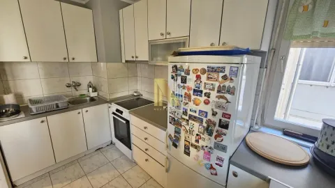 Kuhinja sa belim elementima, šporetom i frižiderom. - image 7