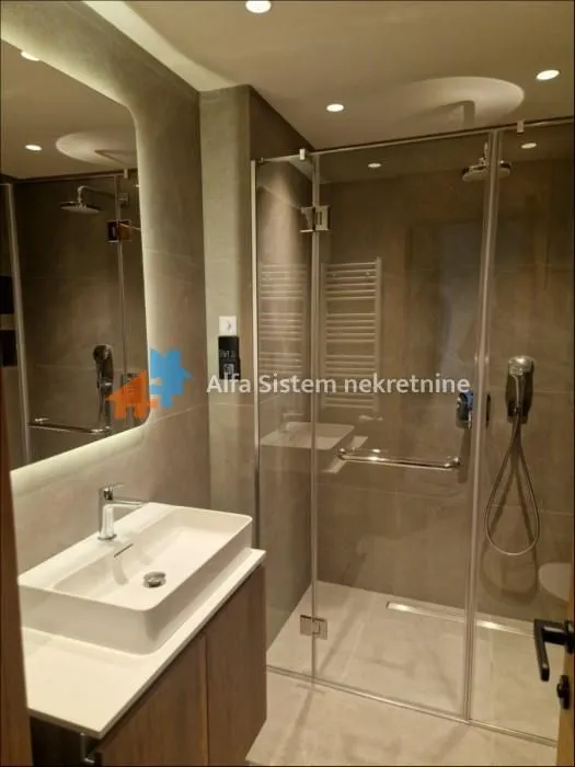 Modernly equipped bathroom with a washbasin and a walk-in shower.
