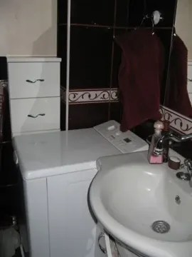 A bathroom featuring a sink and a washing machine. - image 10
