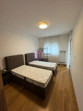 Spavaća soba sa dva singl kreveta i drvenim podom. - image 7