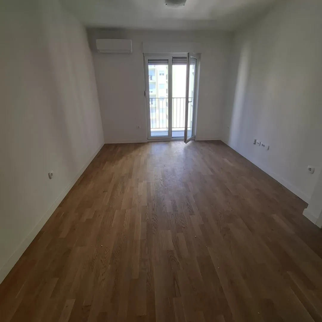 Empty room with hardwood floors and access to the terrace.