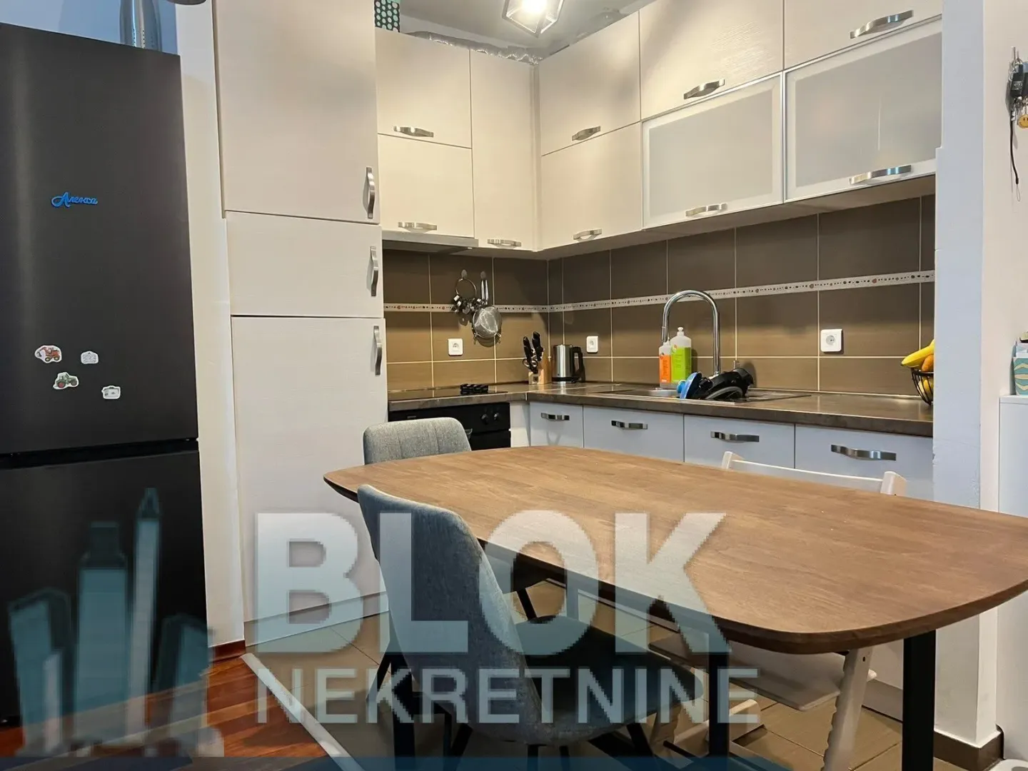Kitchen with a dining table and grey cabinets.